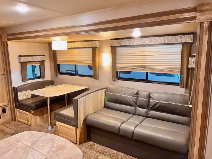 Explore this cozy RV rental living area! Features a dinette, sofa, and bright windows, perfect for your next family road trip.. Coachmen Catalina 2022