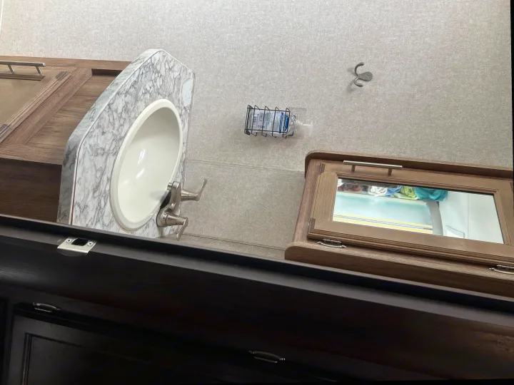 RV rental vanity: Sink, faucet, wall-mounted sanitizer, mirror cabinet. Compact bathroom.. Jayco White Hawk 2019