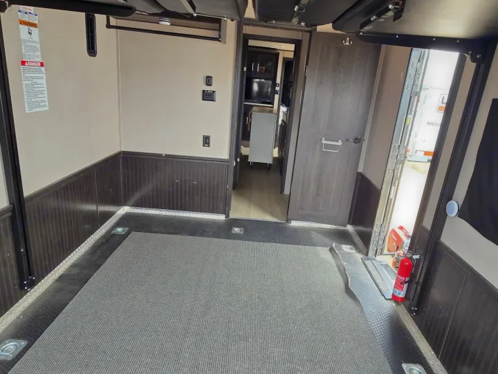 RV rental toy hauler cargo area with durable diamond plate and carpeted floor, tie-downs, and access to living quarters.. Forest River XLR HyperLite Toy Hauler 2020