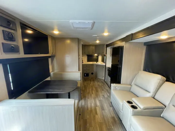 Bright, modern rv rental interior with a full kitchen, dinette, comfy reclining sofa, and TV. Ready for your next adventure!. Starcraft Super Lite 2024