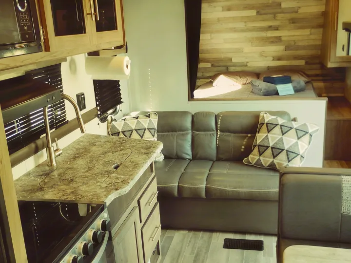 RV rental: Well-appointed interior features kitchen, cozy couch, and rustic bed. Your travel home awaits.. Crossroads RV Zinger Lite 2020