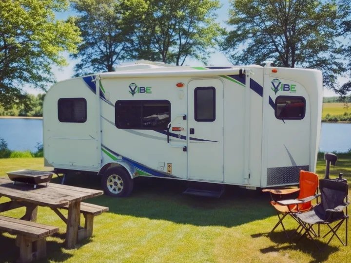 Serene lakeside RV rental: a Vibe travel trailer with picnic table & camping chairs for your outdoor adventure.. Forest River V-Cross Vibe 2012