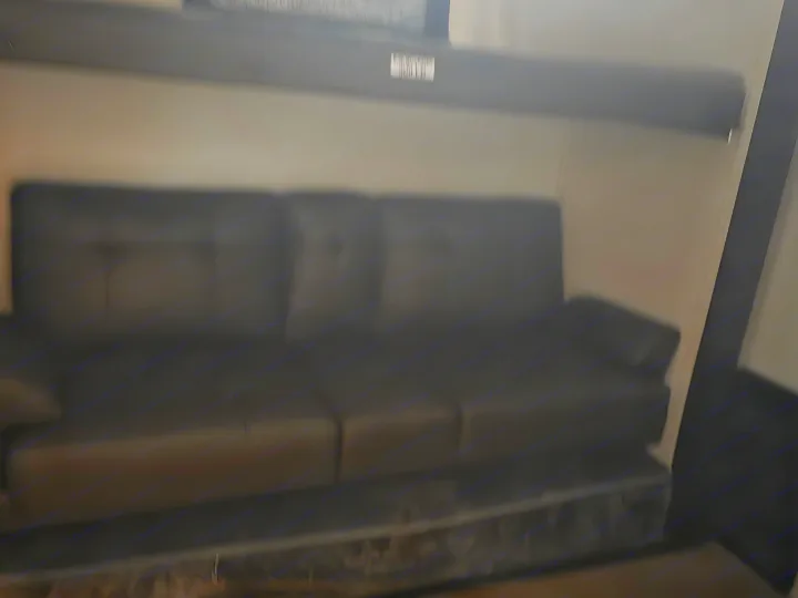 RV rental: Dark, three-seat sofa offers comfortable interior seating.. Forest River Cherokee Alpha Wolf 2026