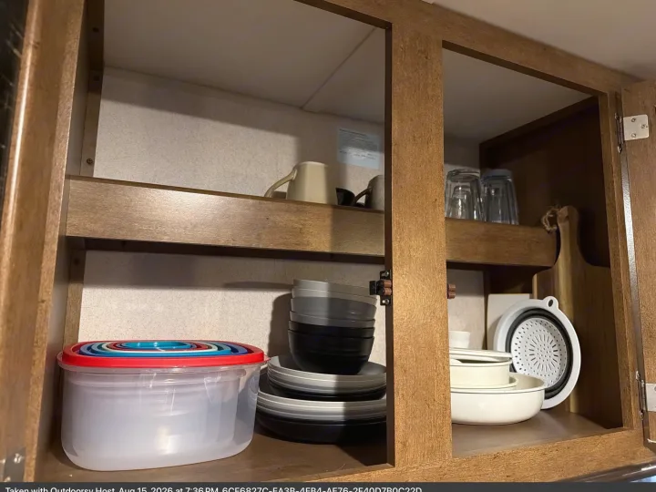 Stay organized in your RV rental! This cabinet holds essential kitchenware: stacked plates, bowls, mugs, glasses, and a colander.. Forest River T27TDSS 2017