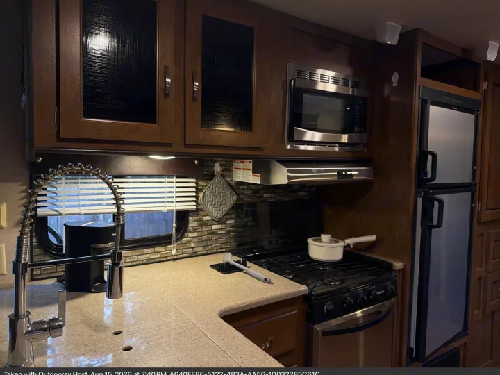 Modern rv rental kitchen with stainless steel appliances: microwave, stove, fridge, and sink. Ready for your adventure!. Forest River T27TDSS 2017