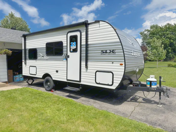 This Jayco Jay Flight SLX Sport Edition travel trailer, ideal for RV rental, is parked on a driveway on a sunny day.. Jayco Jay Flight SLX Sport Edition 2026