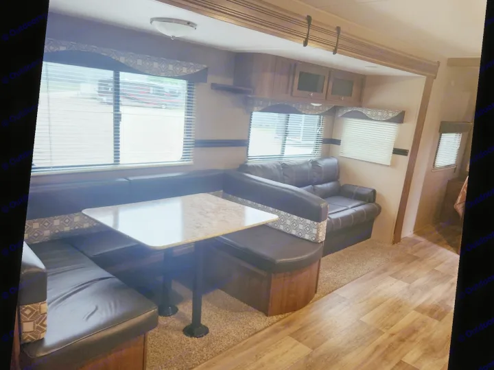 Cozy RV rental living space with a dinette, sofa, and overhead cabinets. Ideal for comfortable travel and family adventures.. Aspen Trail Aspen Trail Trailer 2018