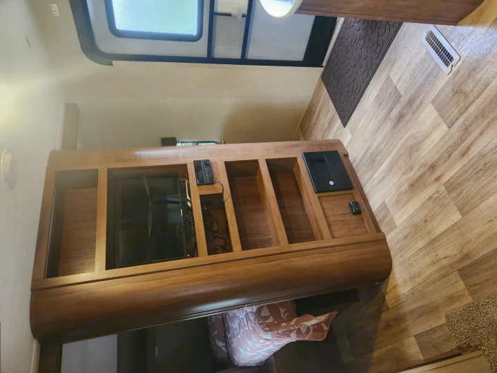 RV rental interior. View of a wood entertainment unit with TV, stereo, and shelving. Light wood-look floor, skylight overhead.. Aspen Trail Aspen Trail Trailer 2018