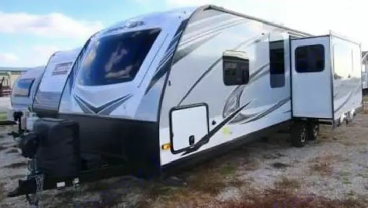 This white and gray travel trailer is perfect for an rv rental, featuring a spacious slide-out and modern design.. Jayco White Hawk 2021