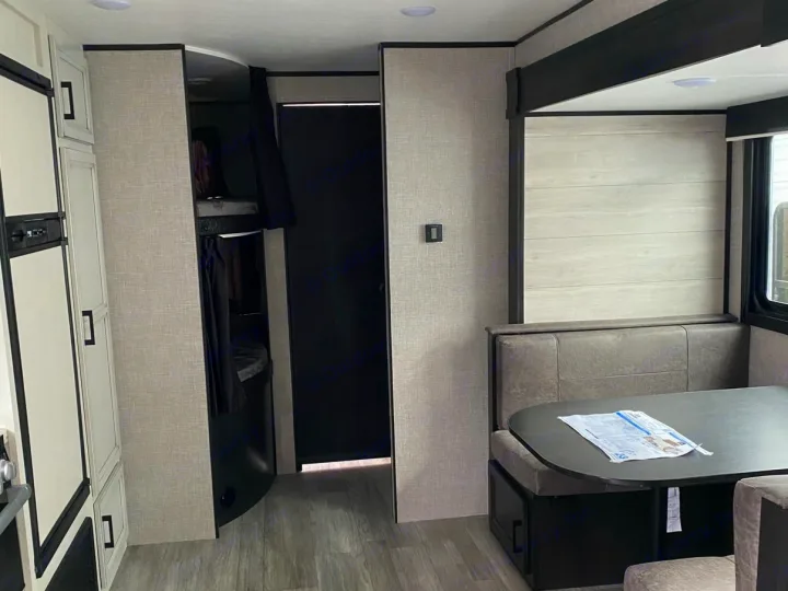 Discover this RV rental's interior: a comfortable dinette, bunk beds with privacy curtains, and kitchen cabinets.. Jayco Jay Flight SLX 2022