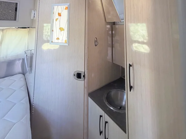 RV rental: Clean, modern interior. Features a comfortable bed, compact kitchenette sink, and storage cabinets.. Airstream International 2015