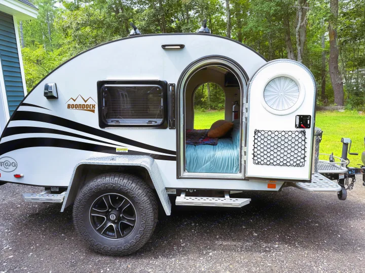 This small, rugged T@G teardrop camper is ready for your next rv rental adventure, showing its comfy bed and off-road tires.. nuCamp T@G 2022