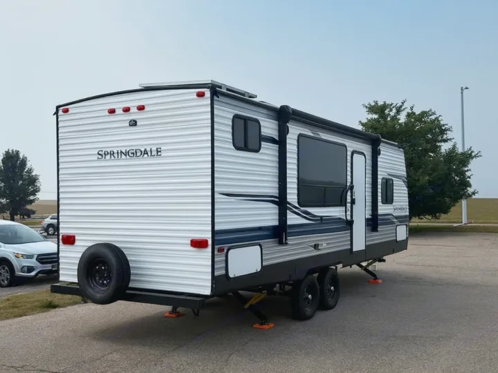Springdale travel trailer, great for an rv rental. Parked & leveled on orange blocks with a rear spare tire.. Keystone RV Springdale 2022