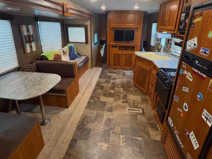 Spacious RV rental interior featuring a dinette, full kitchen, and an adventure-themed fridge. Perfect for road trips!. Starcraft AR-One Maxx 2016