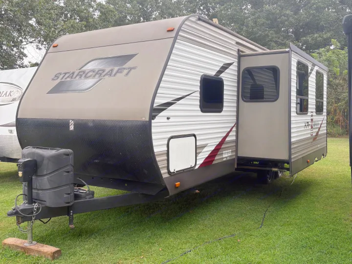 Gray and white Starcraft travel trailer RV rental with an extended slide-out, parked on a lush green lawn.. Starcraft AR-One Maxx 2016