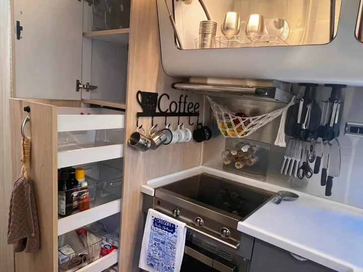 Well-organized rv rental kitchen featuring compact storage, a coffee station, and cooking essentials for travelers.. Airstream Globetrotter 2022