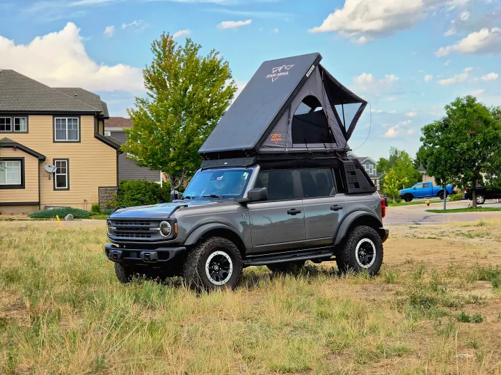 Adventure-ready gray Ford Bronco with a San Hima rooftop tent, perfect as an RV rental for camping trips.. Ford bronco 2021