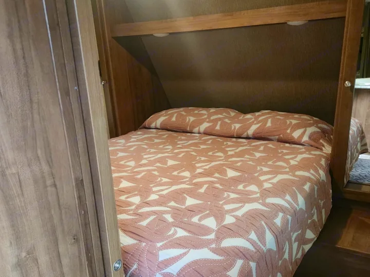 RV rental: Efficient overhead storage featuring a neatly tucked pink patterned cushion, showcasing practical space in a compact interior.. Aspen Trail Aspen Trail Trailer 2018