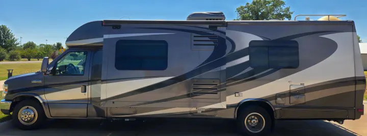 Side view of a modern Class C motorhome, perfect for your next rv rental adventure. Features sleek design and ample windows.. Phoenix Cruiser Phoenix Cruiser Motorhome 2013