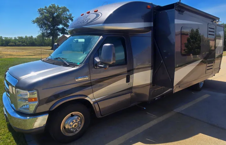 This gray Class C Phoenix Cruiser RV rental, a spacious motorhome, is parked outdoors on a sunny day, ready for adventure.. Phoenix Cruiser Phoenix Cruiser Motorhome 2013