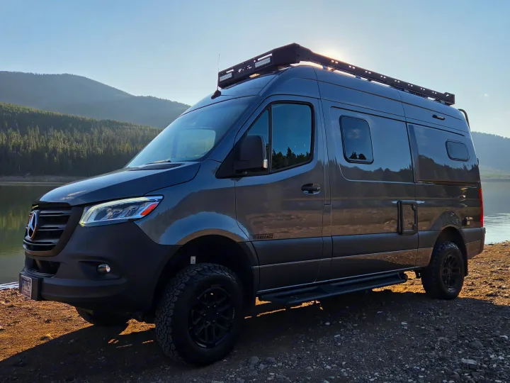 Winnebago Revel RV rental by a lake, surrounded by mountains. This adventure van is ready for off-grid exploration!. Winnebago Revel 2025