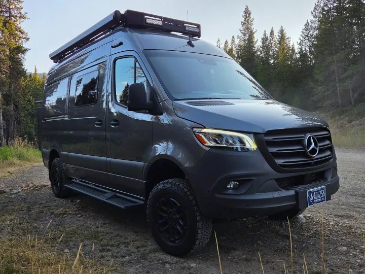 This gray Mercedes Sprinter camper van, equipped for off-road adventure, is perfect for an RV rental wilderness escape.. Winnebago Revel 2025