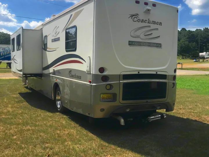 Coachmen Cross Country RV rental motorhome, with an extended slide-out, parked on grass.. Coachmen Cross Country 2003