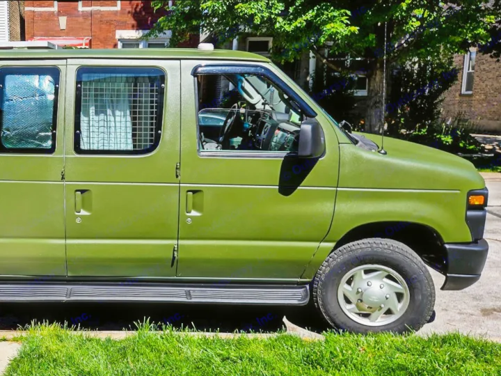 An olive green, textured cargo van parked on a sunny street, ready for a rugged RV rental adventure.. Ford Econoline 2012