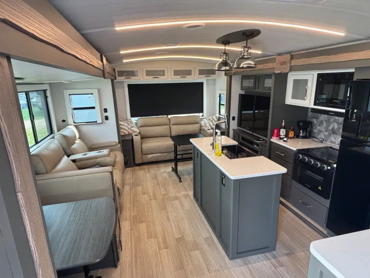 Spacious RV rental interior featuring a modern kitchen, living area, and dining nook, ideal for comfortable travel.. Keystone RV Bullet Premium 2025