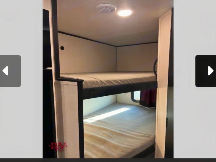 RV rental bunk beds: comfortable sleeping space in an RV, featuring two mattresses, an overhead light, and a vent.. Jayco Jay-flight 2026