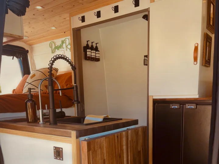 Stylish camper van rv rental featuring a kitchen sink, cozy bed, shower entrance, and fridge for your next adventure.. Mercedes Sprinter 2500 2019