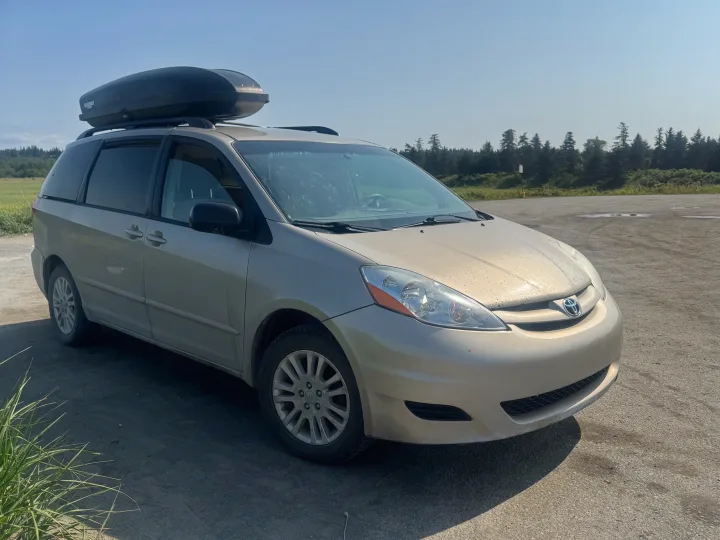 Tan Toyota Sienna minivan, roof cargo box. Perfect for long drives. Find your ideal RV rental for any trip.. Toyota Sienna 2009