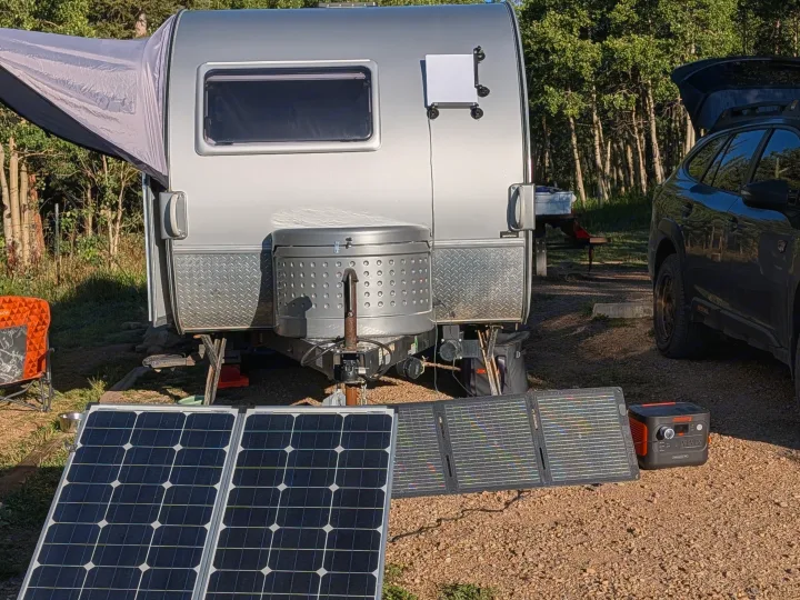 RV rental campsite: silver travel trailer with solar panels, Jackery power station, and SUV. Perfect for off-grid camping setup.. nuCamp T@B CS-S 2017
