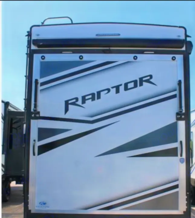 Rear view of a "RAPTOR" toy hauler RV rental, featuring a large ramp door with bold black and gray graphics. Ready for adventure!. Keystone RV Raptor Toy Hauler 2022