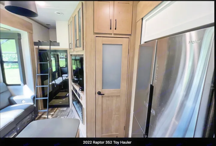 RV rental: Inside this 2022 Raptor 352 toy hauler, featuring a modern kitchen with a Haier fridge, pantry, loft bed, and living area.. Keystone RV Raptor Toy Hauler 2022