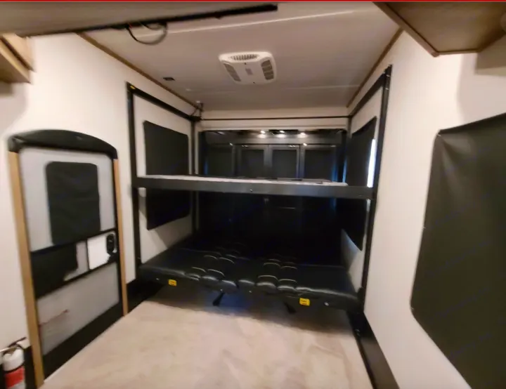 Inside this **rv rental**: a versatile toy hauler garage with convertible bunk beds and seating. Ready for adventure!. Keystone RV Raptor Toy Hauler 2022