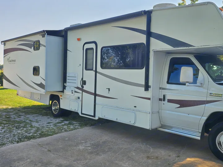 Side view of a white Coachmen Freelander Class C RV rental with its slide-out extended, parked on concrete.. CoachMen Freelander 2012