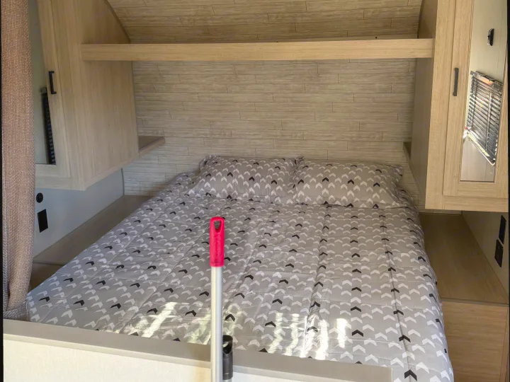 Cozy RV rental bedroom: a bed with chevron pattern, light wood walls, and integrated storage units.. Coachmen Catalina 261 bh 2026