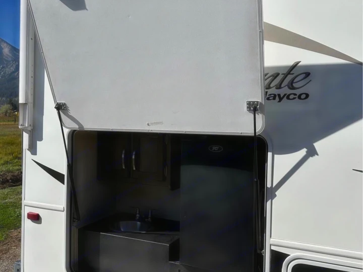 RV rental outdoor kitchen with a sink, fridge, and cabinets, making camping meals easy.. Jayco Alante 2018