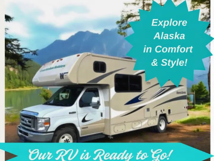 Our beige RV rental, perfect for exploring Alaska in comfort and style, is ready by a scenic lake.. Winnebago Minnie Winnie 2023