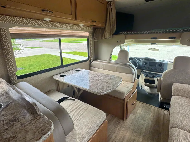 Spacious rv rental interior featuring a dinette, kitchen, bunk, and cab. Ideal for comfortable travel.. Thor Freedom Elite 2017