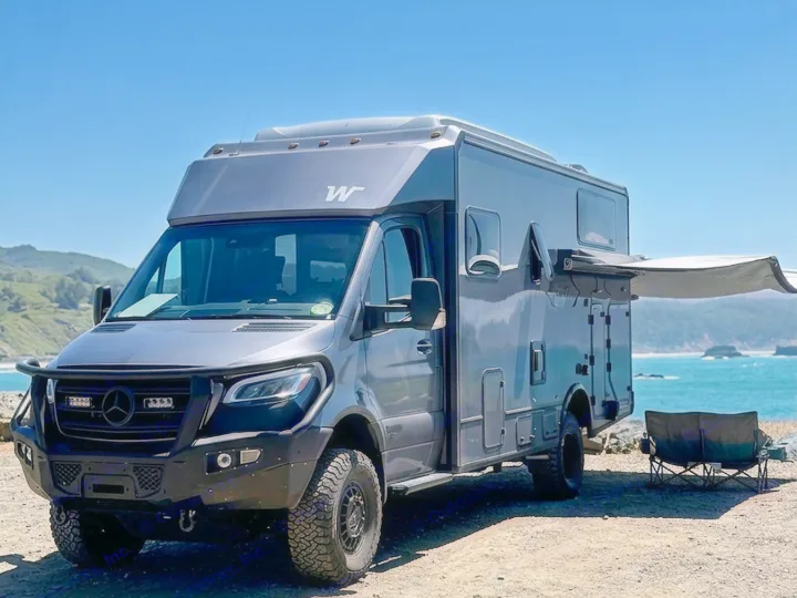 Adventure awaits with this rugged Mercedes Sprinter camper van rv rental parked by the ocean. Perfect for overlanding & beach camping.. Winnebago Ekko 2025