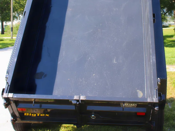 Empty black Big Tex dump trailer bed, signs of use. Great for rentals, like hauling gear for an RV rental trip.. Big Tex 70SR 2027