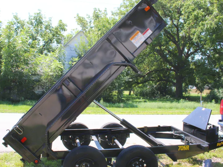 Black 705R dump trailer with raised bed & hydraulic lift system, ready for heavy loads. Explore rental options for projects and RV travel.. Big Tex 70SR 2027