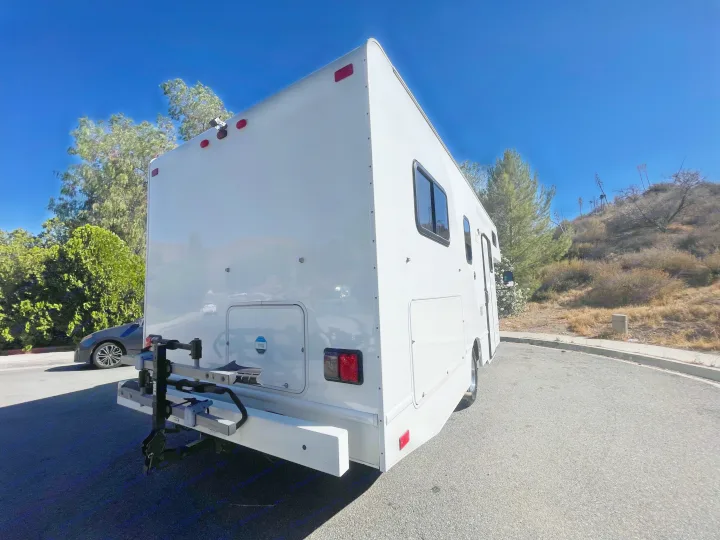 Rear view of a white RV rental, showing a bike rack, backup camera, and storage hatch. Great for camping & travel.. Thor Majestic 2017