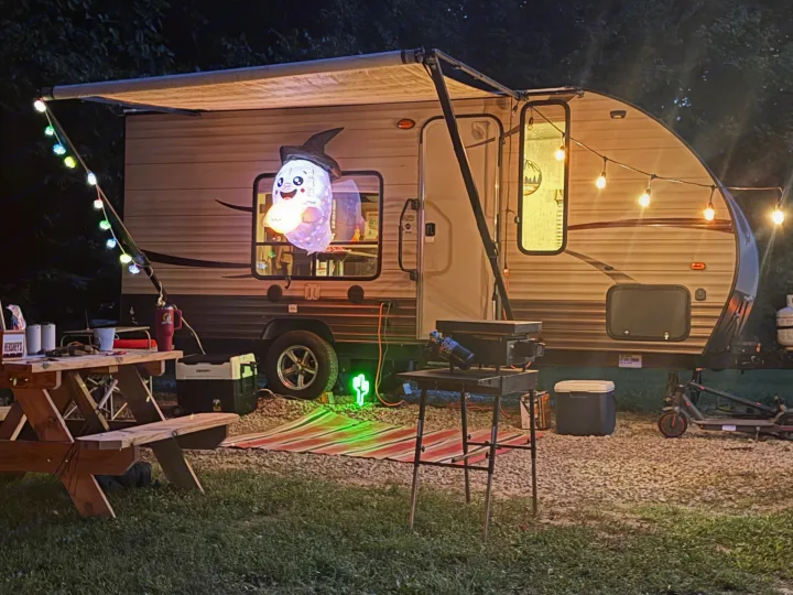 Enjoy a spooky-fun RV rental camping setup! This travel trailer features a ghost, string lights, picnic table, and grill.. Forest River Cherokee Wolf Pup 2016