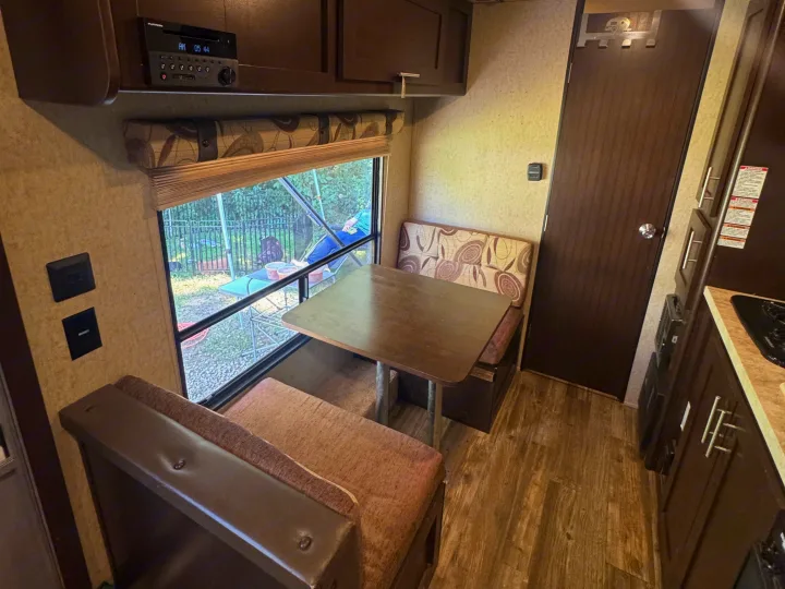 Cozy RV rental interior: dinette seating, window with a view, integrated entertainment system, and kitchen.. Forest River Cherokee Wolf Pup 2016