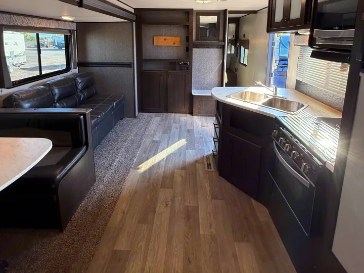Inside this **rv rental**: a sleek kitchen, comfy dinette, and sofa, ideal for road trip comfort and adventure.. Heartland RVs Pioneer 2021