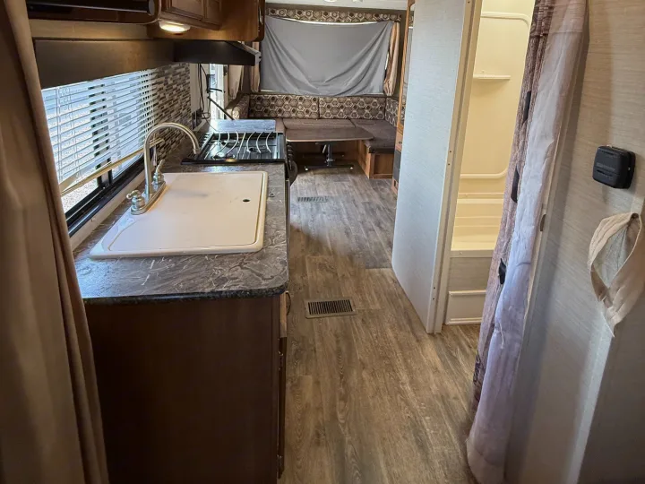 Spacious RV rental interior with kitchen, dinette, and bathroom. Perfect for travel adventures.. Keystone RV Springdale SRT 2016