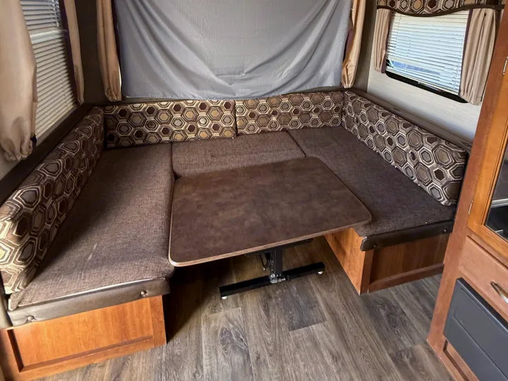 RV rental dinette area: U-shaped seating, table, and windows. Ideal for meals or relaxing on your journey.. Keystone RV Springdale SRT 2016
